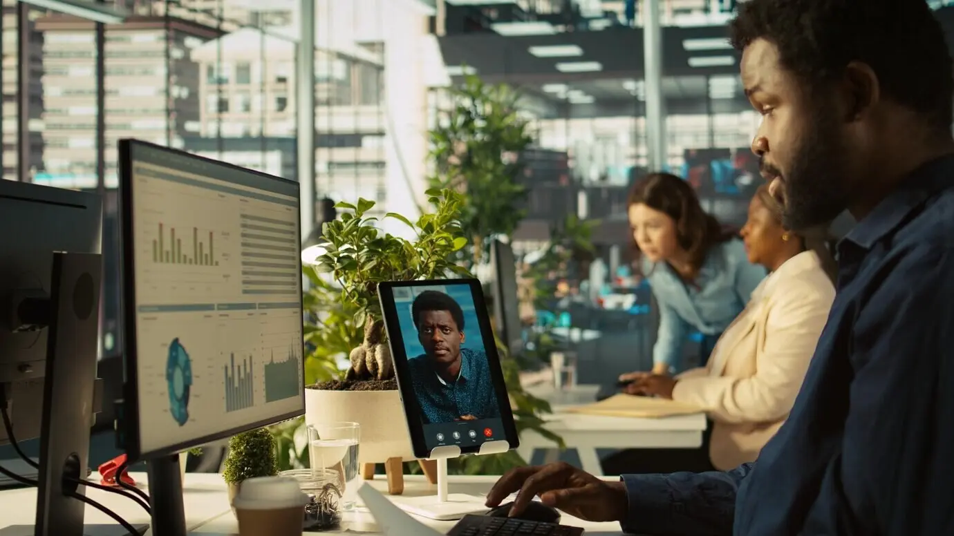 Сотрудник в офисе общается с менеджером во время видеозвонка.